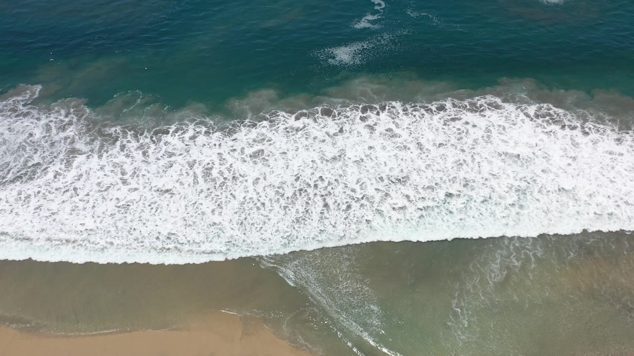 White wave crest stretched across teal water.