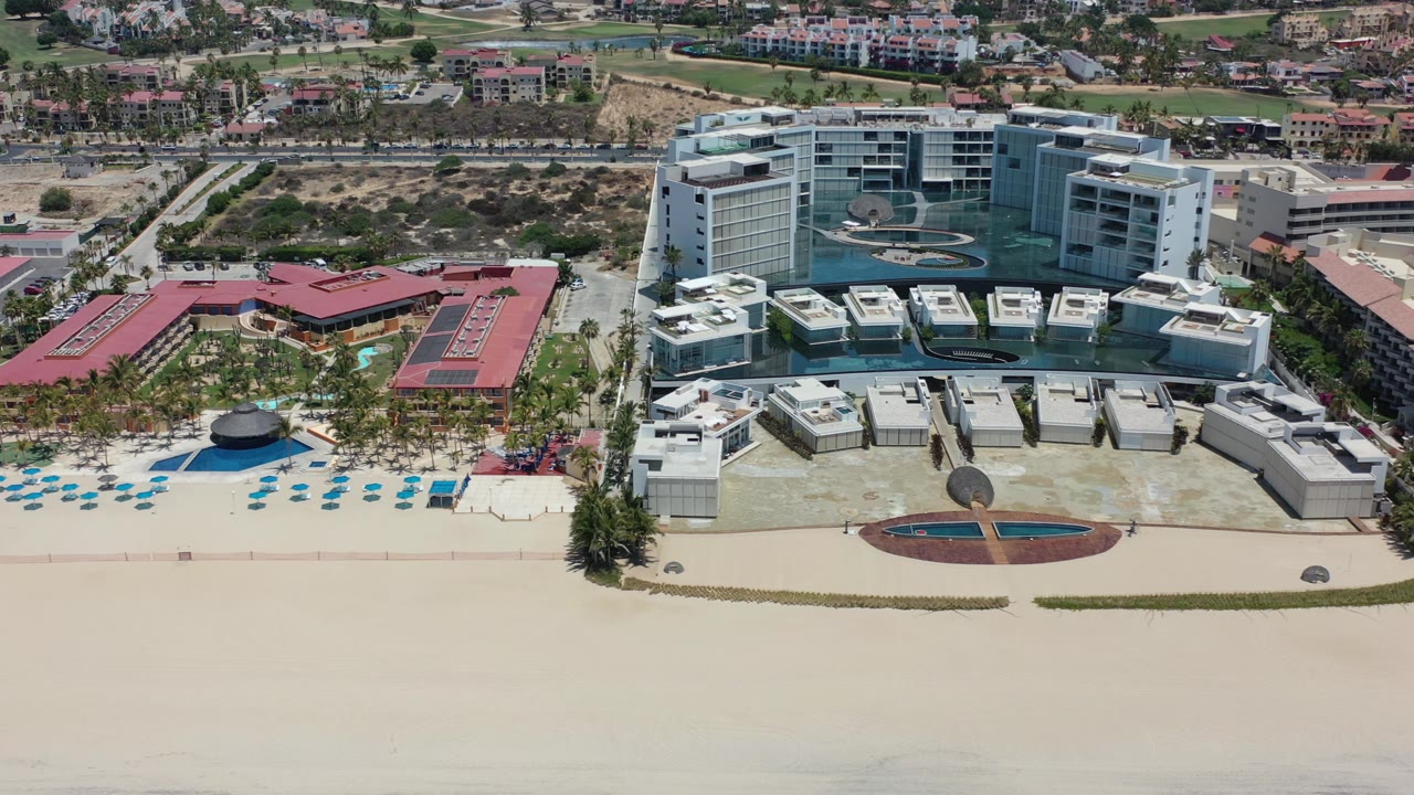 Modern beachfront high-rises behind a large open beach.