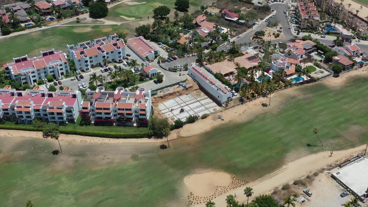 Aerial view of red-roof residences beside a golf course.
