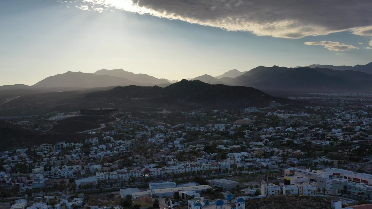 Backlit mountains above a Los Cabos residential area.