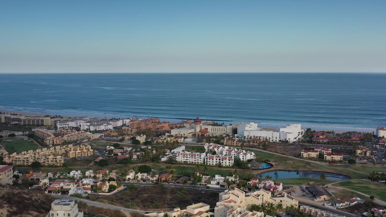 Wide aerial view of coastal buildings and blue ocean