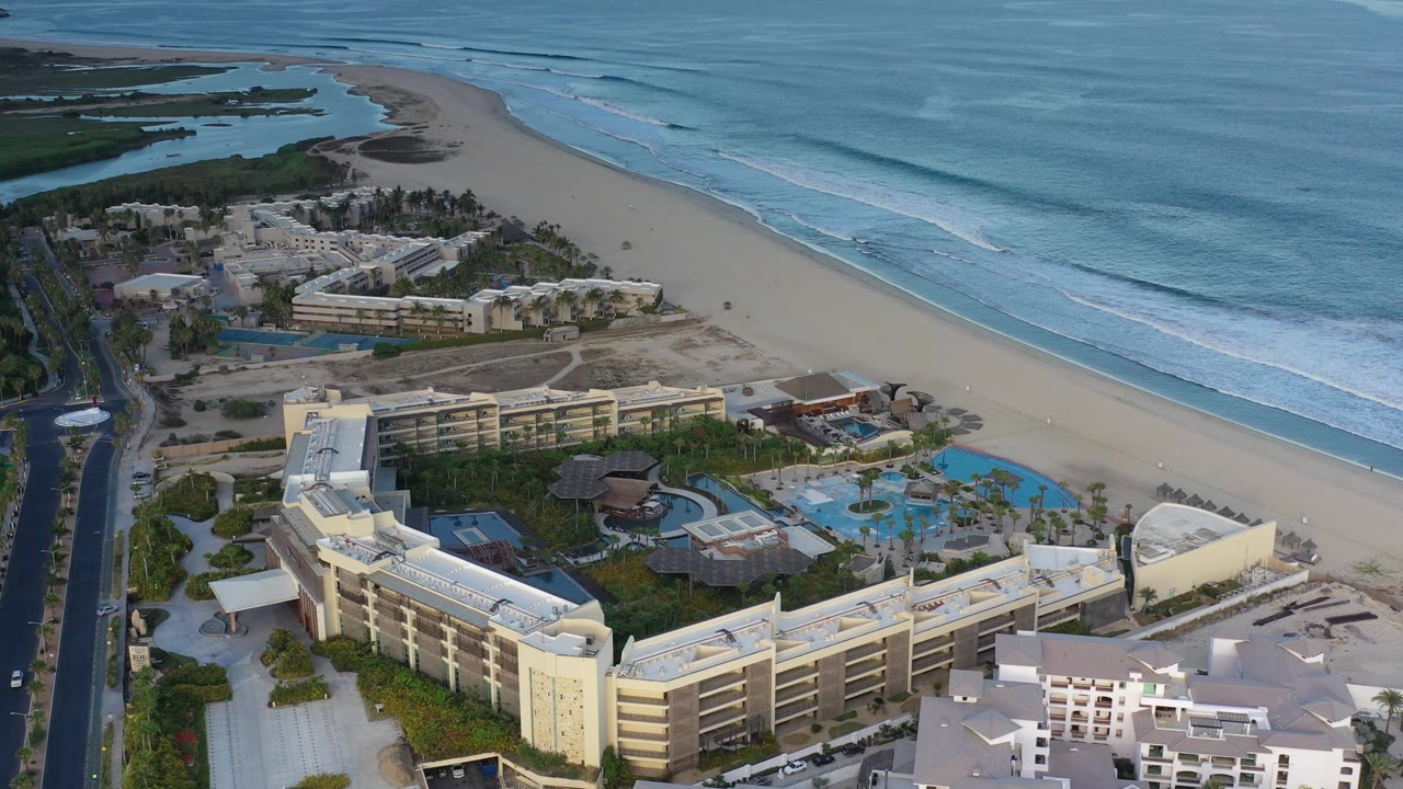 Beach resort complex with road, pools, and shoreline