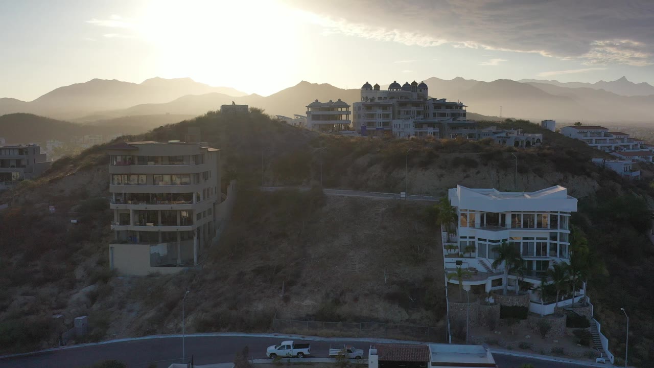 Sunrise over hillside buildings and distant mountains