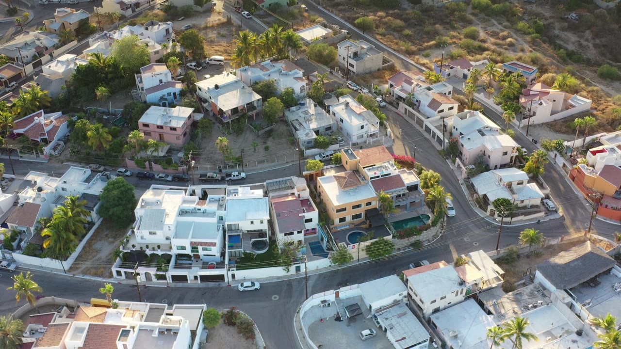 Aerial view of modern homes, palm trees, and curving streets.