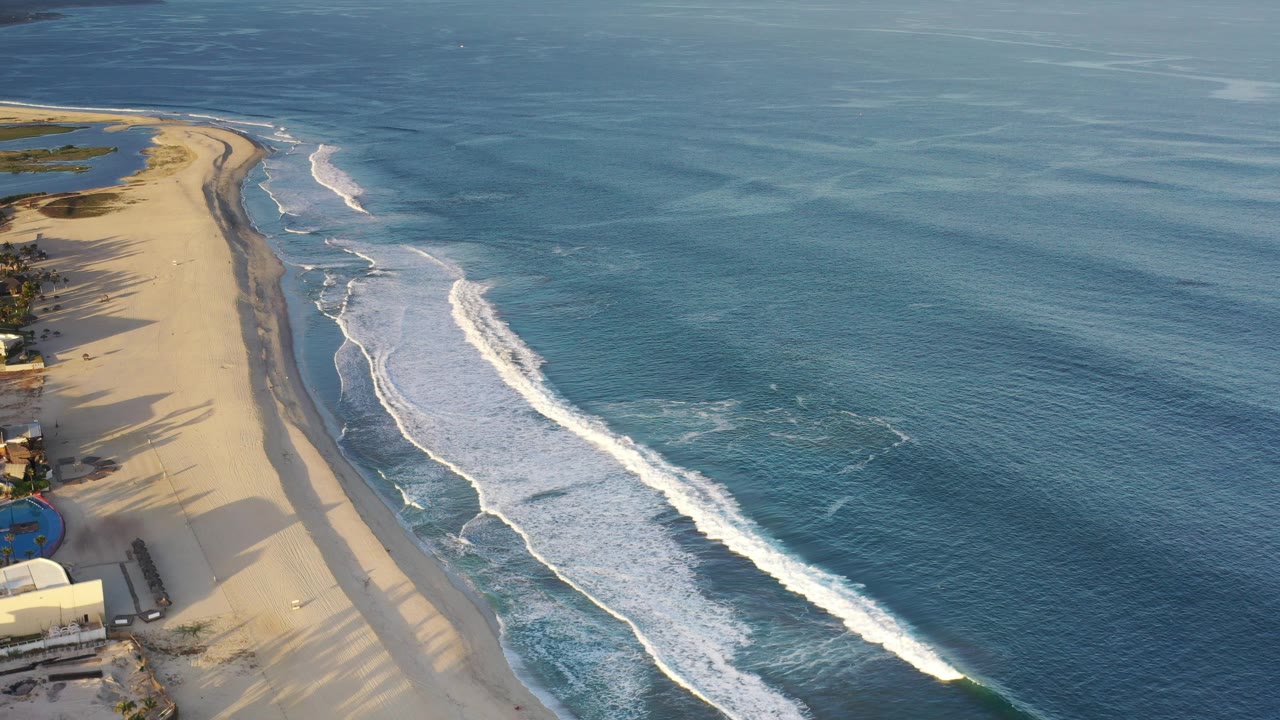 Aerial view of sandy coast and breaking ocean waves
