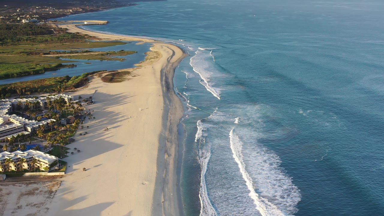 Aerial beach view with ocean surf and coastal buildings