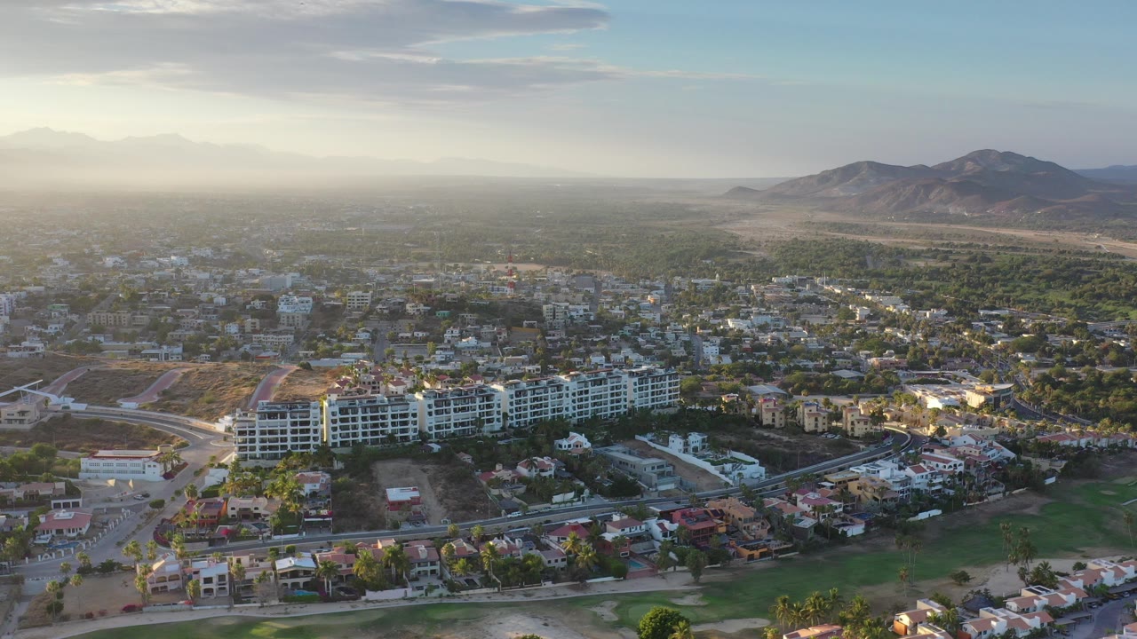 Aerial view over Los Cabos buildings with mountains in the distance