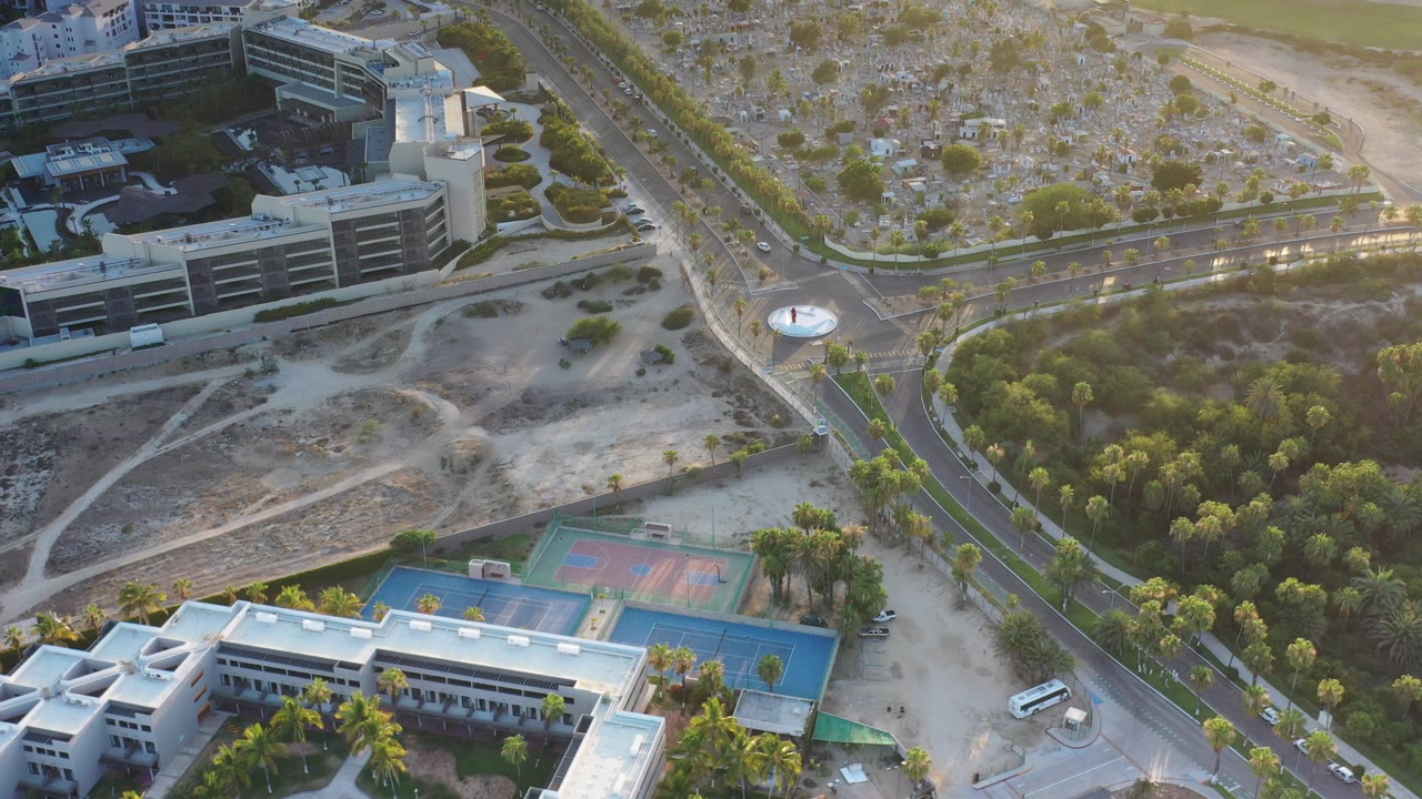 Aerial view of buildings, sports courts, roads, and trees
