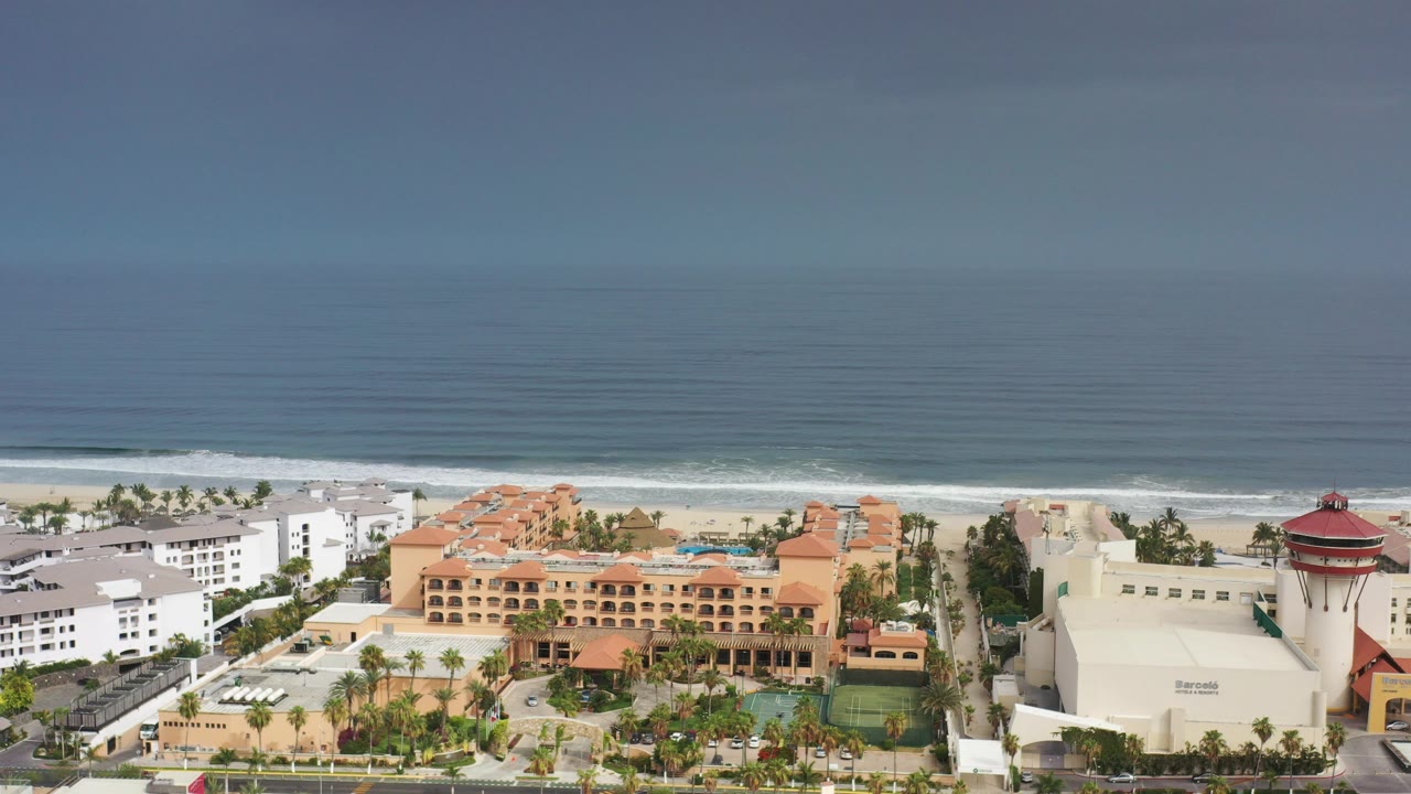 Elevated resort view with beach, surf, and ocean horizon.