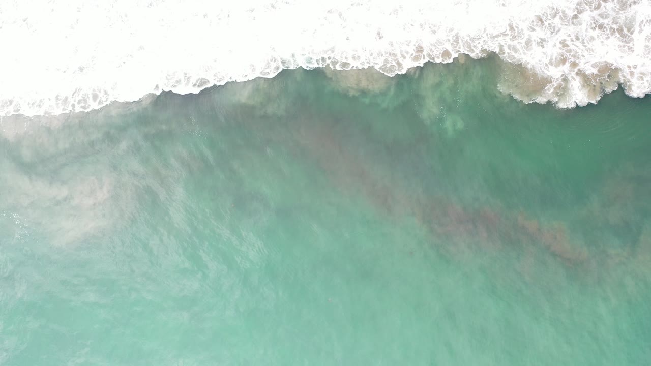 Overhead turquoise water with white surf at the top edge