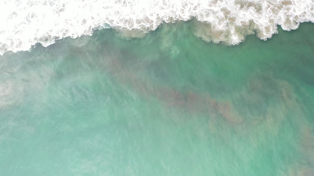 Foam line over clear emerald ocean