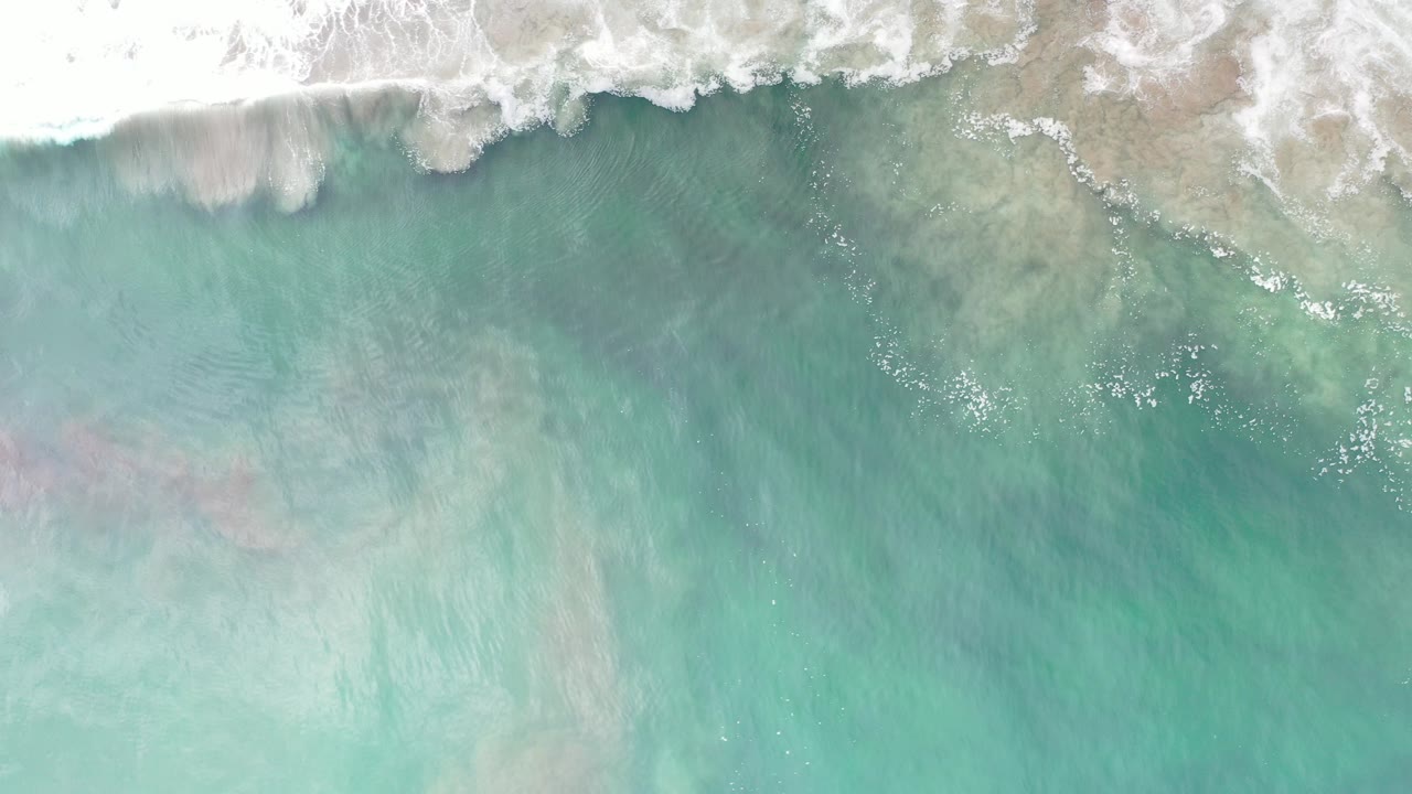 Overhead turquoise water with white surf at the top edge.