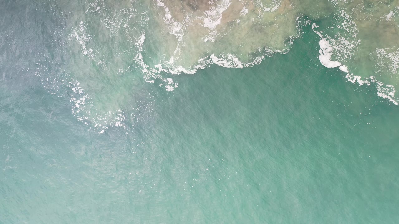 Light surf over pale coastal shallows