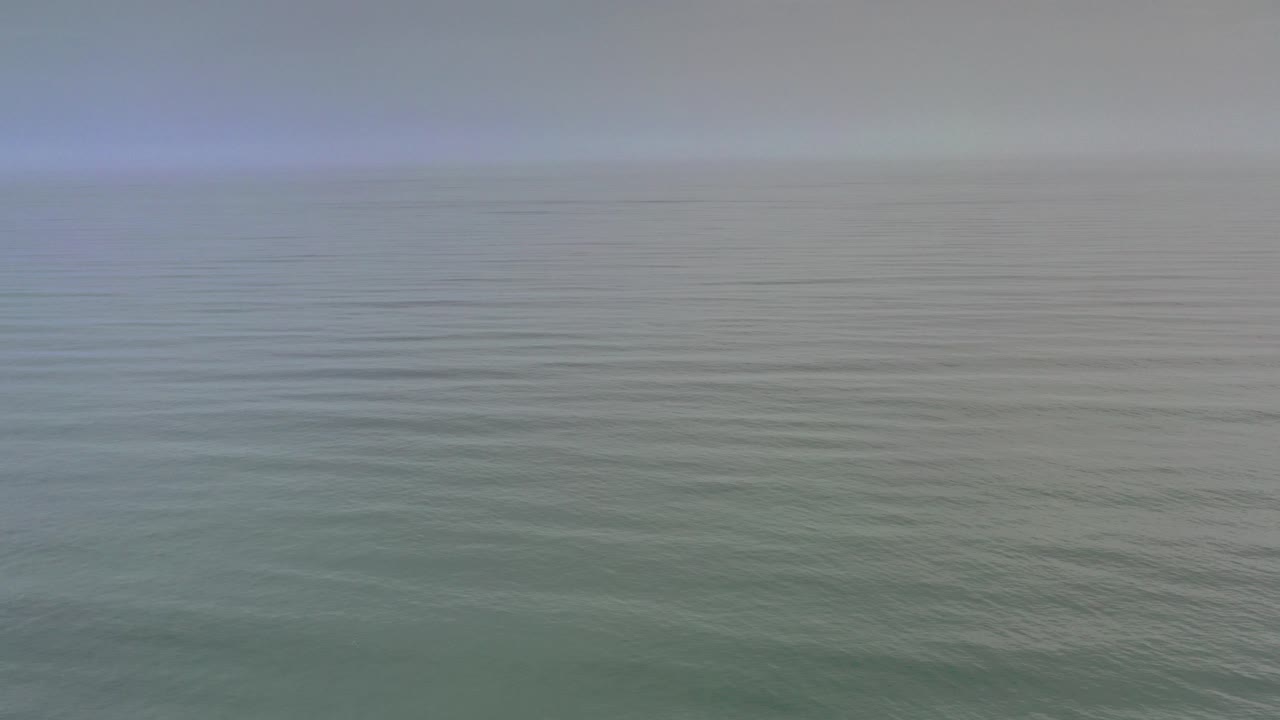 Blue gray ocean under a cloudy horizon