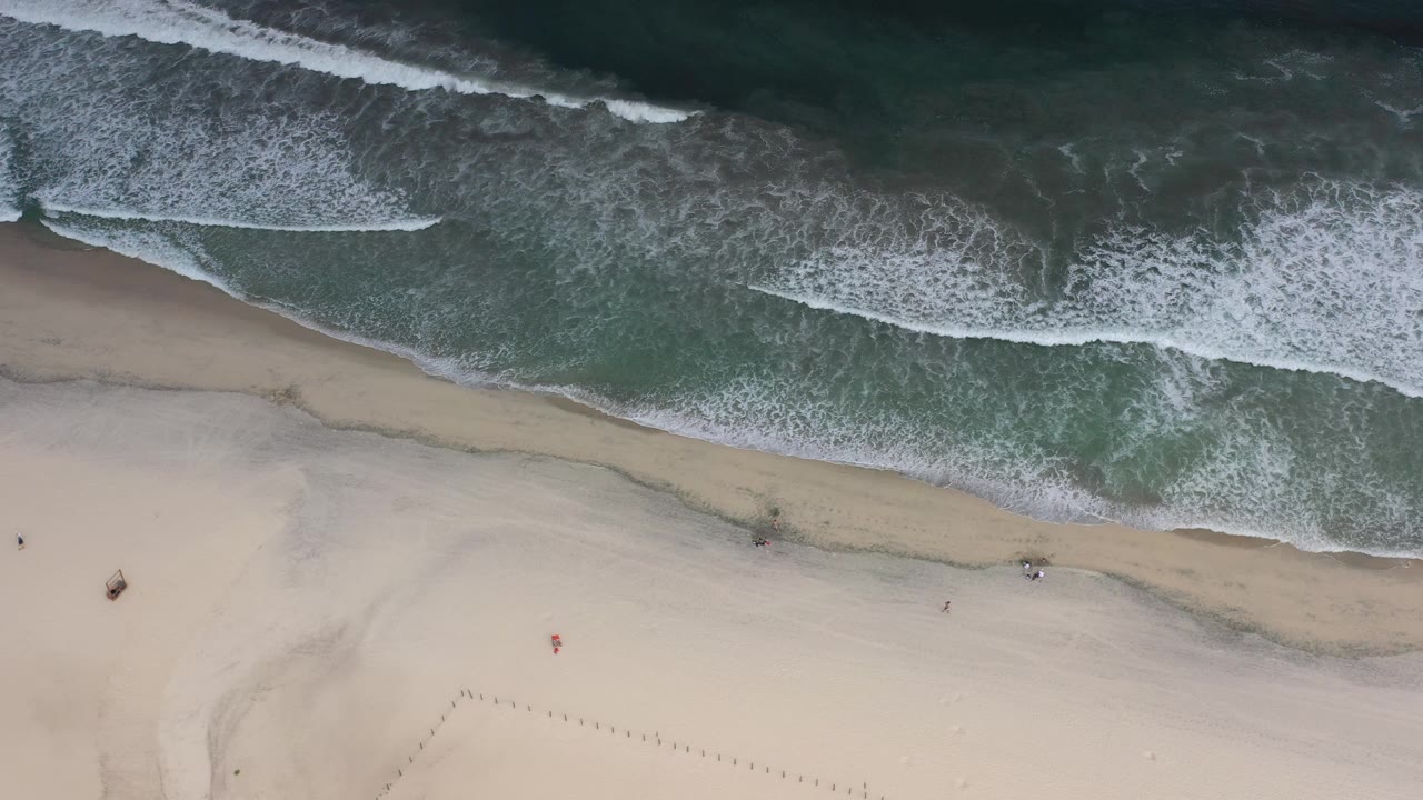Overhead surf washing onto pale sand