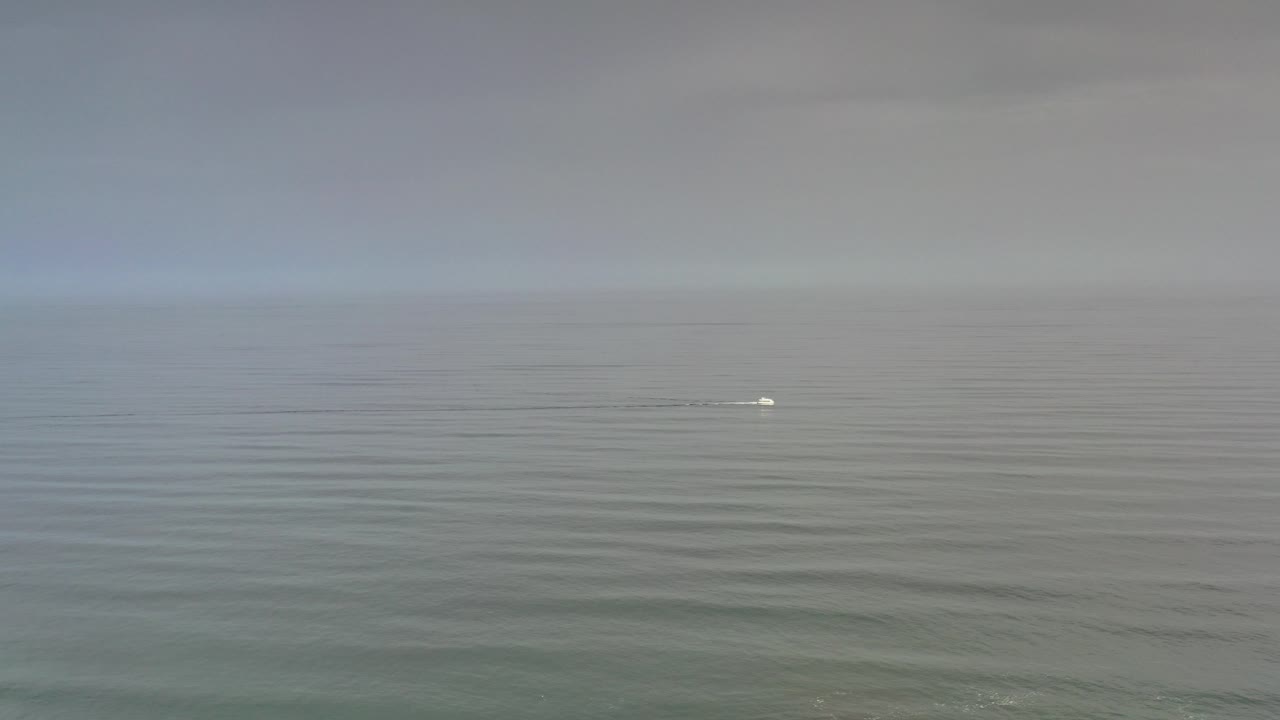 Opening frame of the Los Cabos ocean horizon under gray cloud cover, with low water ripples and no visible people.