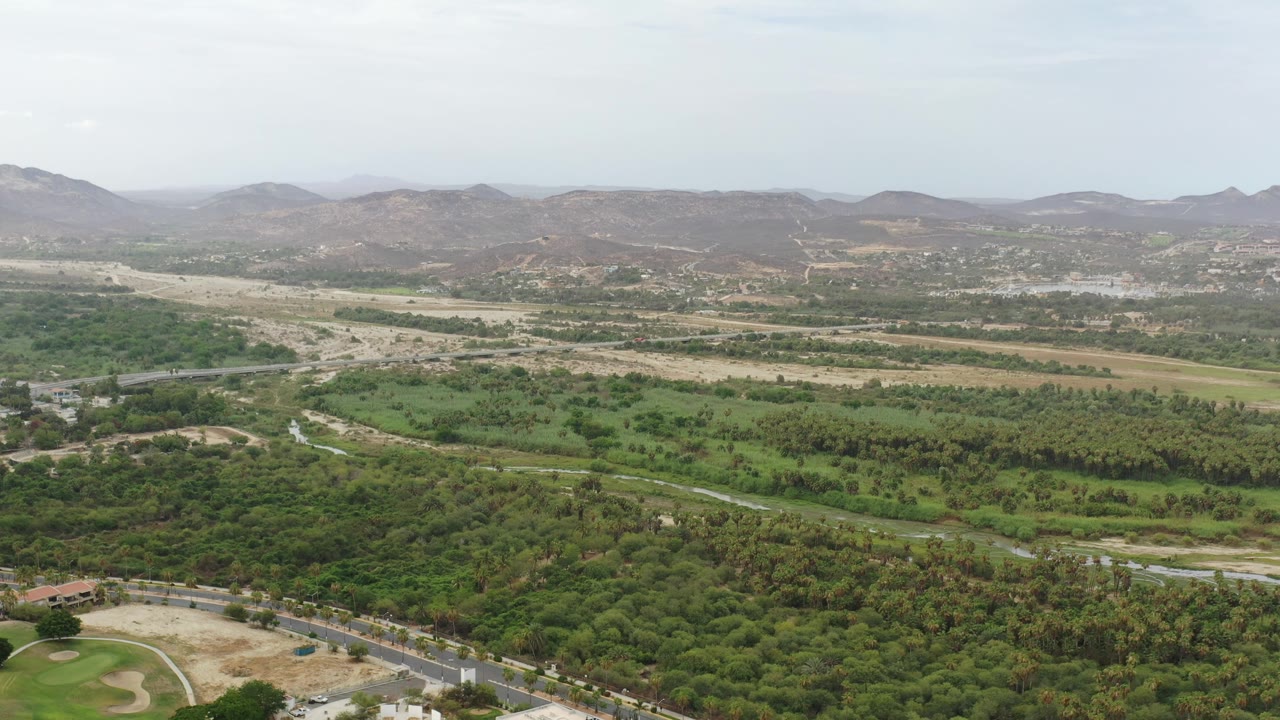 High view of roads crossing green and tan terrain.