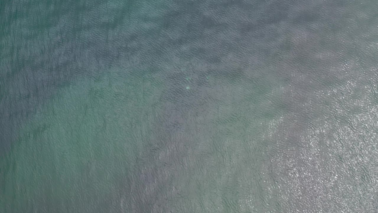Muted turquoise water with darker rippled areas