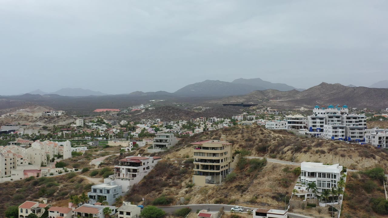 Overhead view of hillside buildings and hazy mountains.
