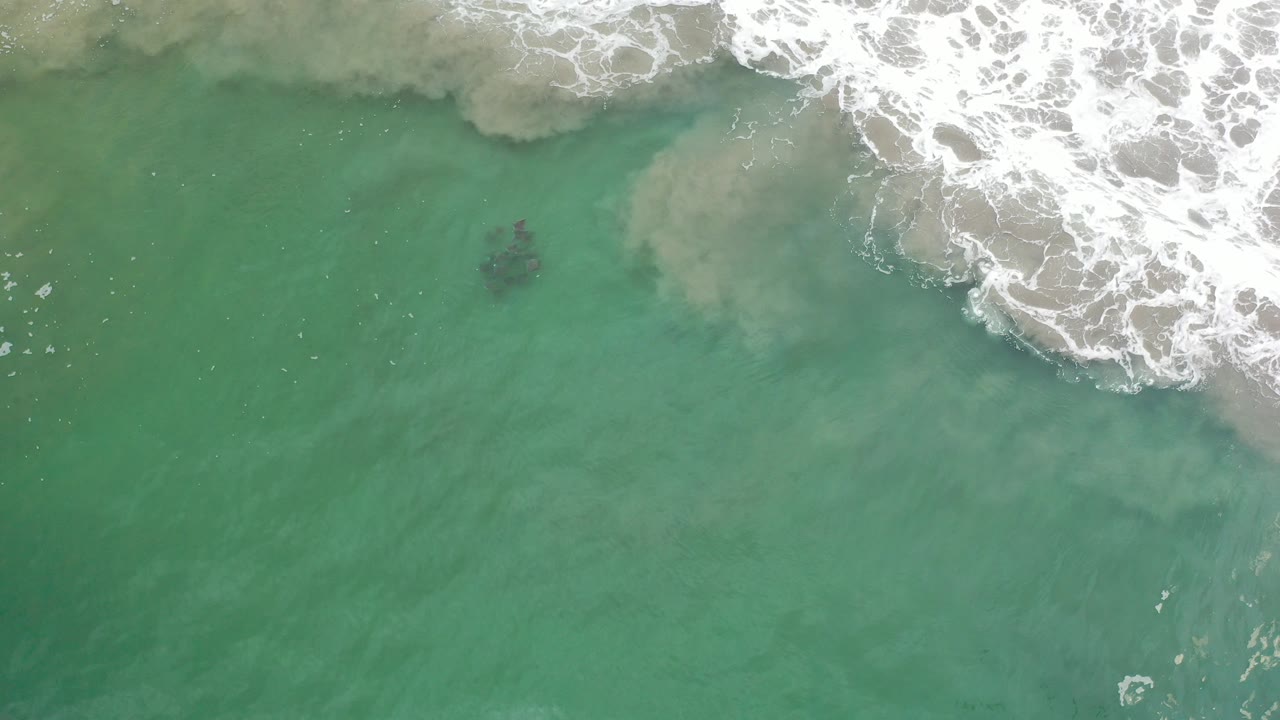 Overhead turquoise water with white surf at the top edge