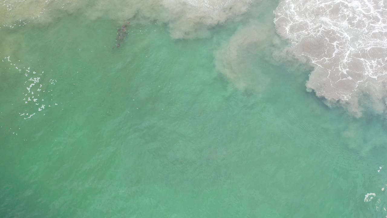 Turquoise water with surf foam at the top and small bubbles