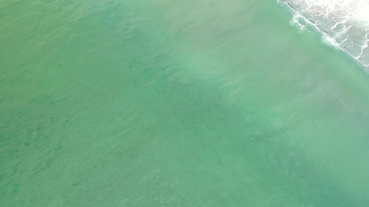 Mostly green water with faint underwater texture and surf in the corner.