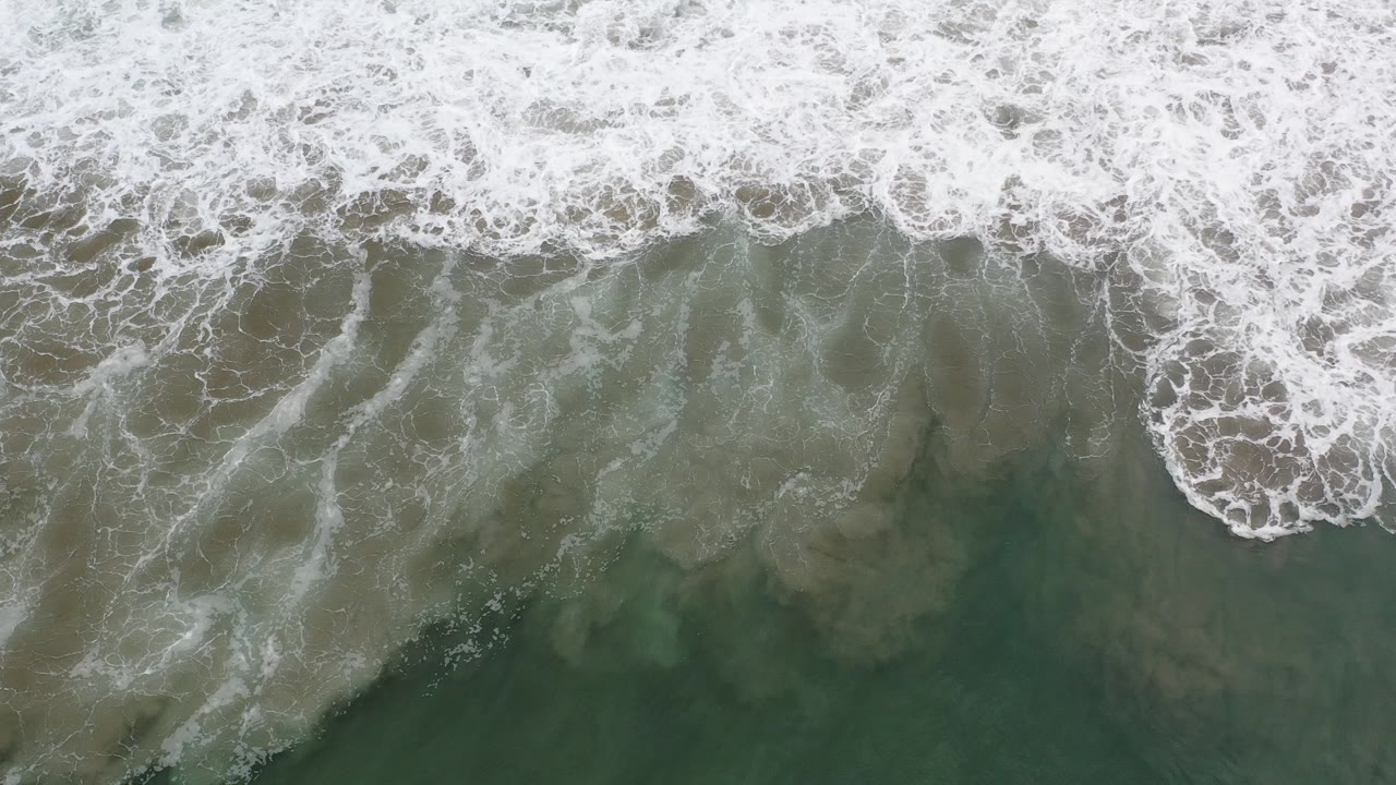 Overhead surf foam and green-blue ocean water.