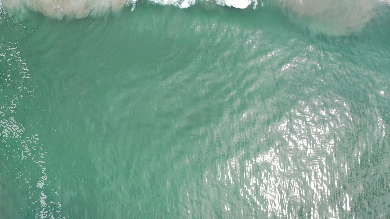 Turquoise water with faint surf and strong reflected light