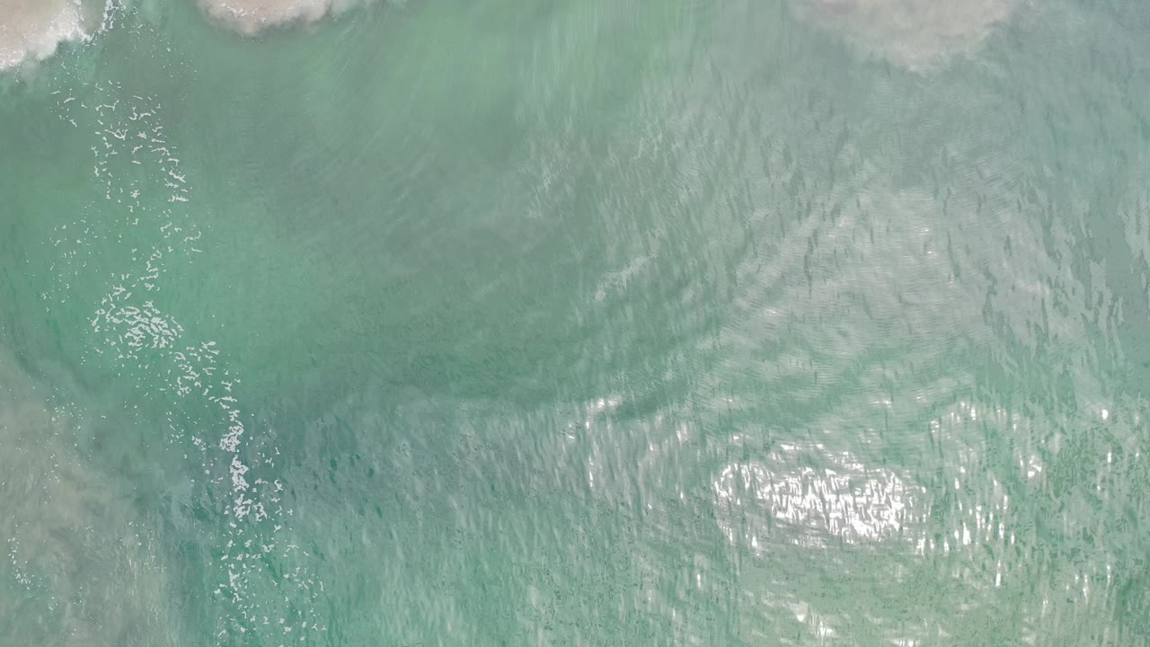 Top-down ocean surface with turquoise water and light ripples.