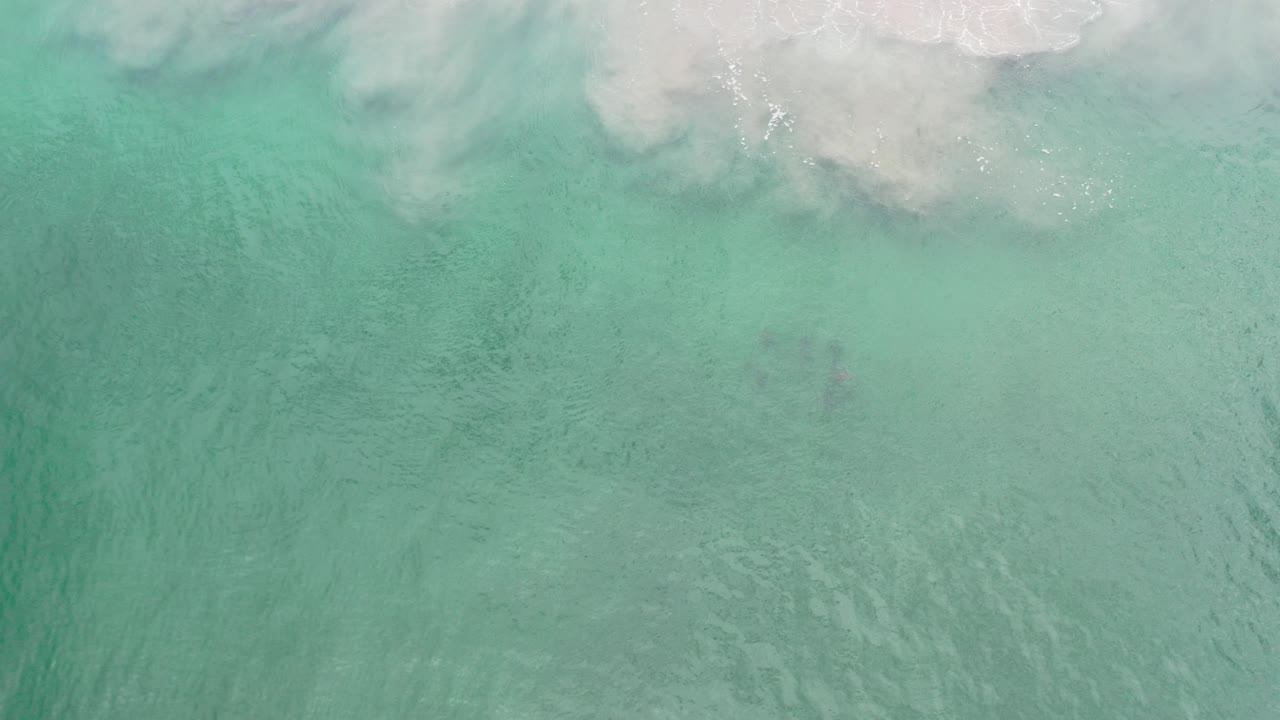 Overhead turquoise water with pale surf at the top edge.
