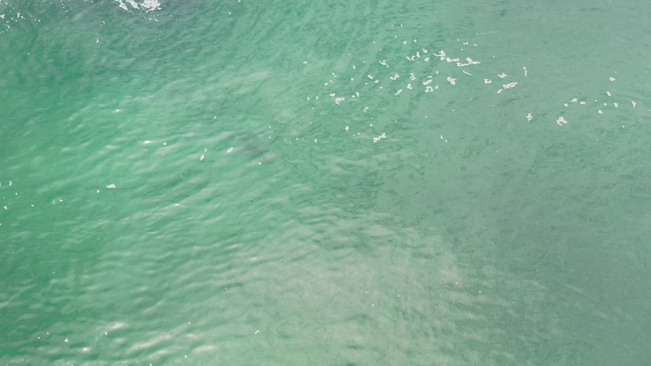 Clear shallow seawater with pale sand below