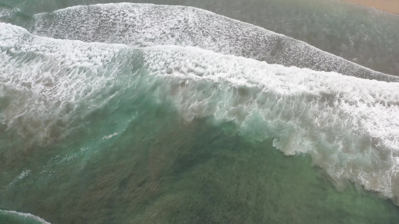 Breaking surf and mottled green water near beach