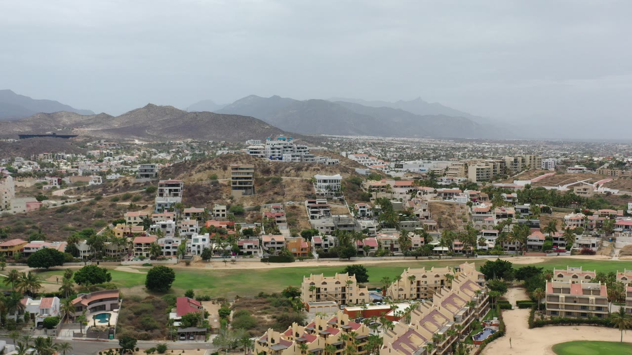 Wide aerial view of hillside homes with distant mountains