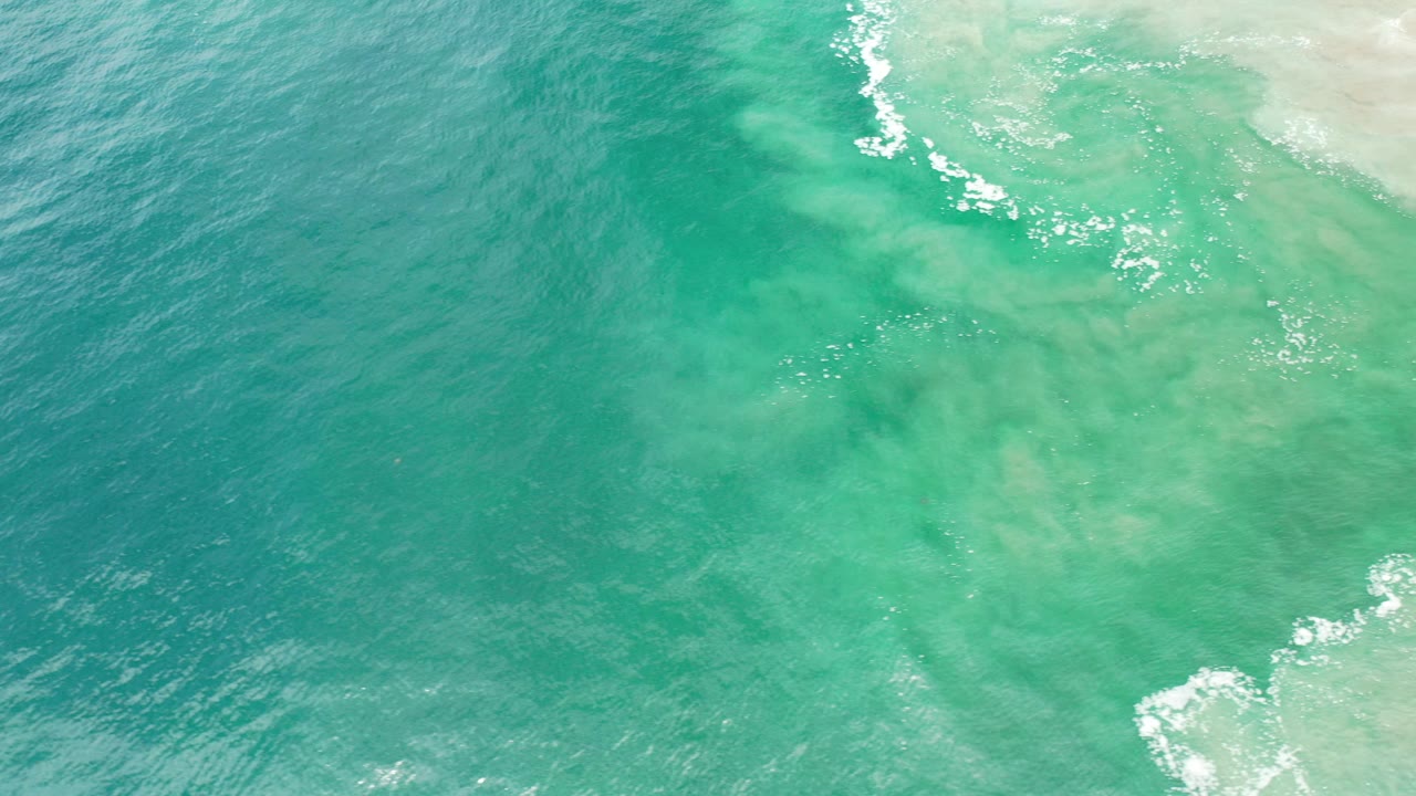 Green ocean water with white foam near the top edge.