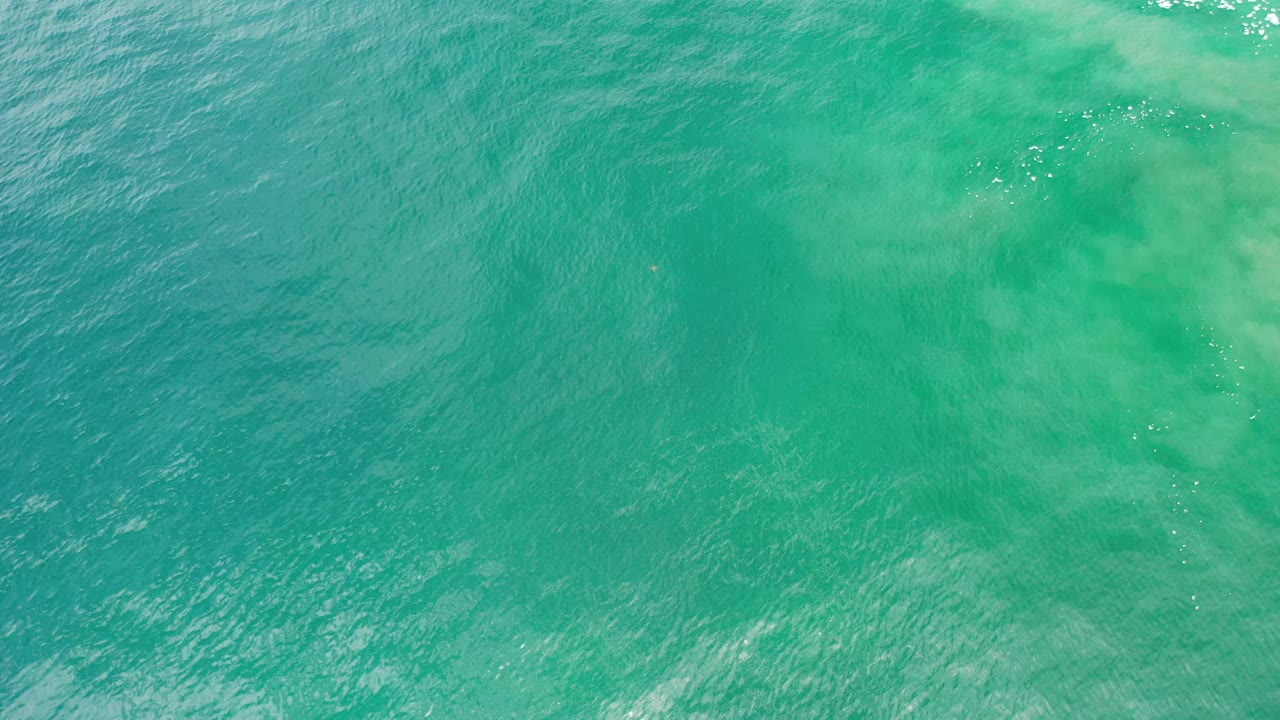 Turquoise Los Cabos water shows a lighter band near the top of frame, small wave texture, and no visible people.