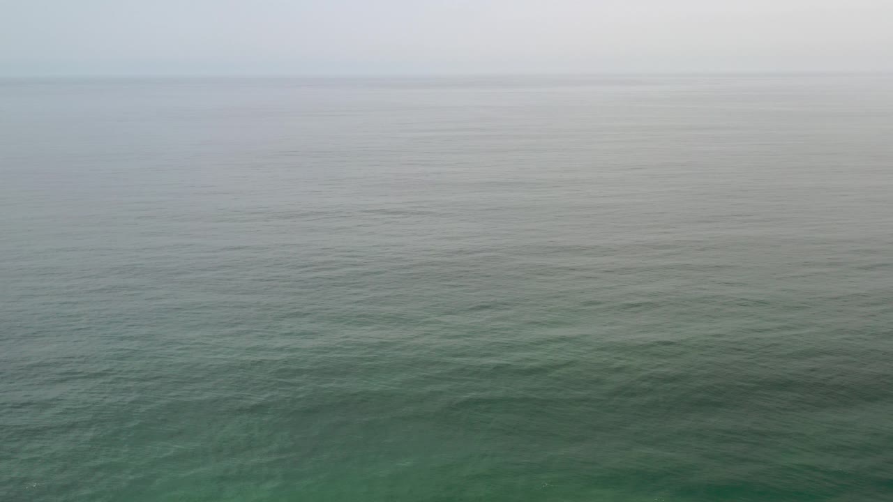 Cloudy sky over green-blue ocean water
