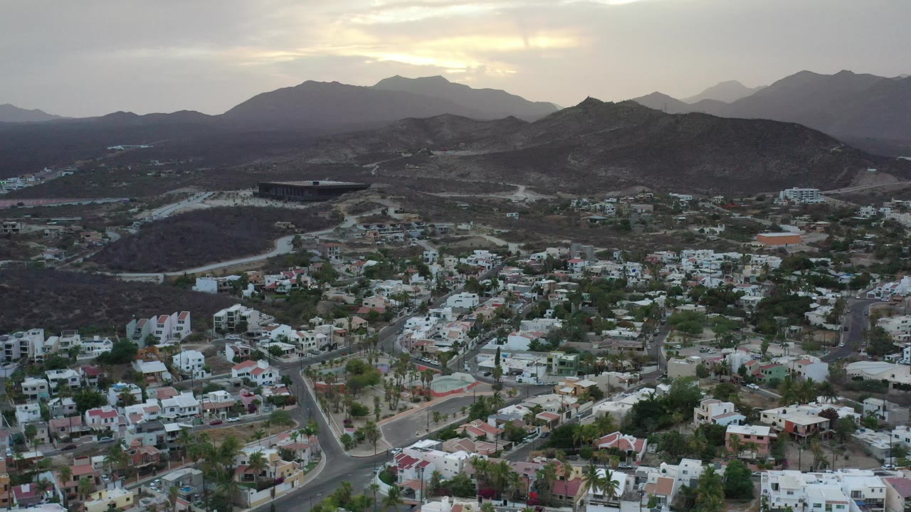 Wide aerial of town, hills, and mountain horizon