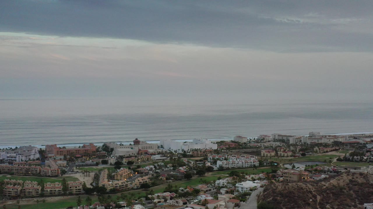 Aerial coastal neighborhood with ocean and cloudy sky