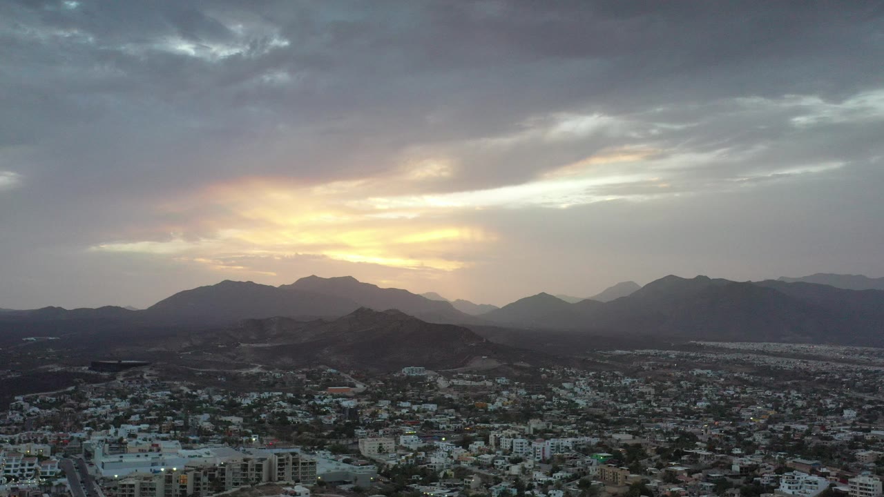 Cloudy sunset over a Los Cabos urban valley and mountains.