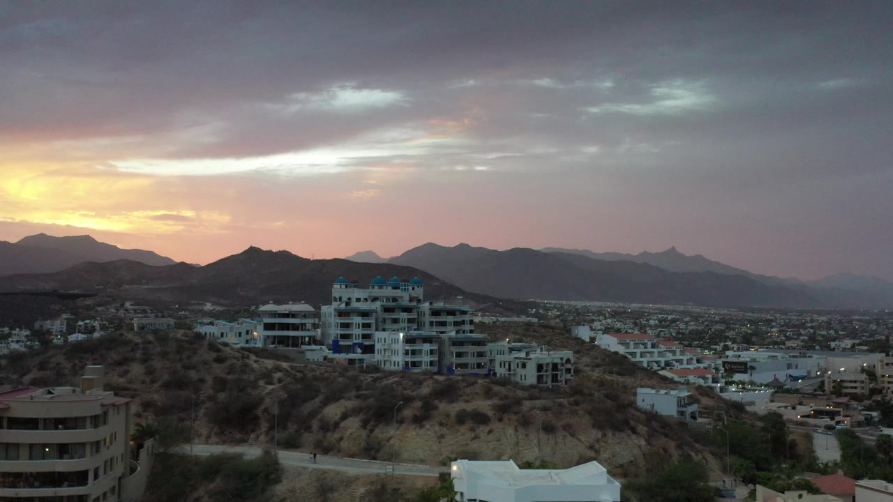 Wide city view with hills and sunrise color on the horizon