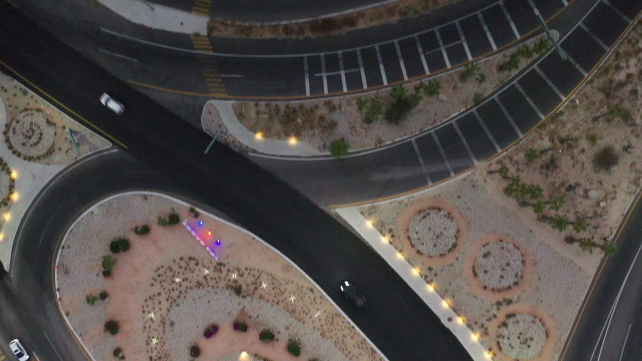 Top-down roads around desert landscaping with two visible cars.