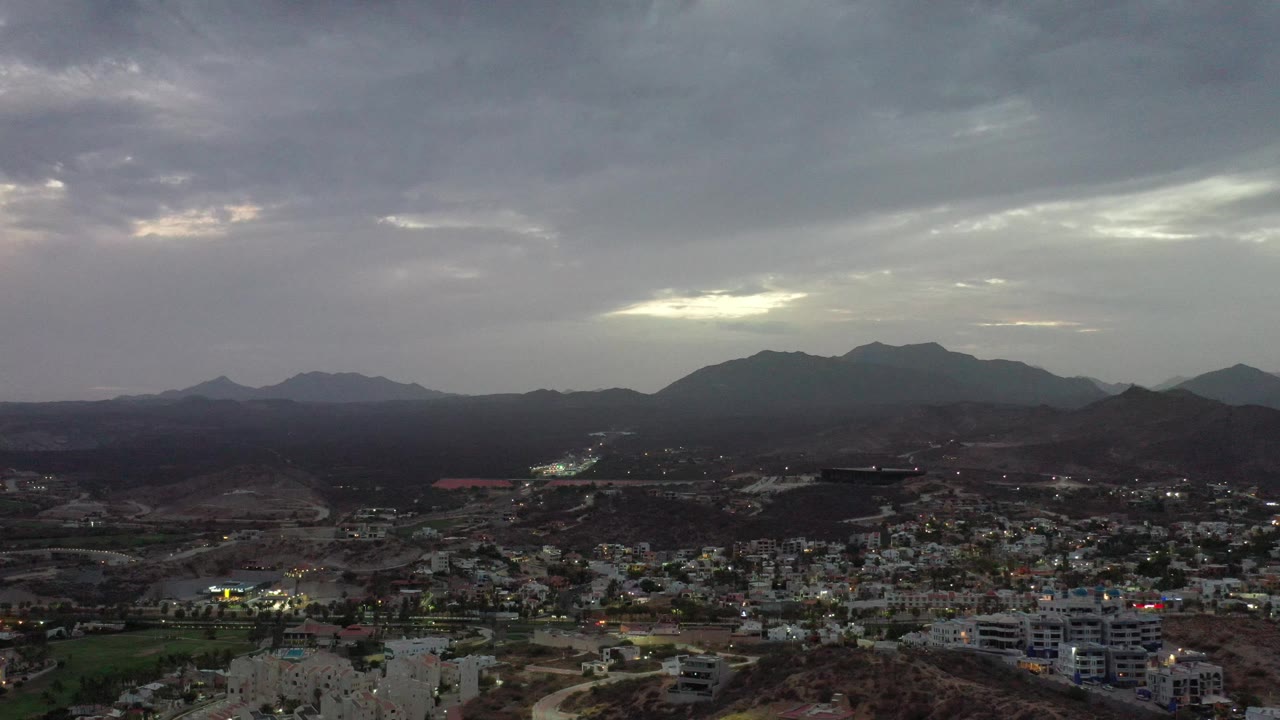 Overcast sky above a mountain-backed city.
