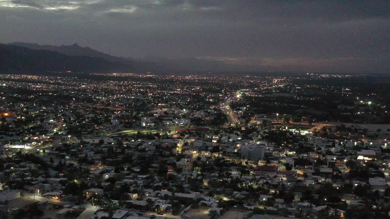 Aerial city lights with bright road line and cloudy sky