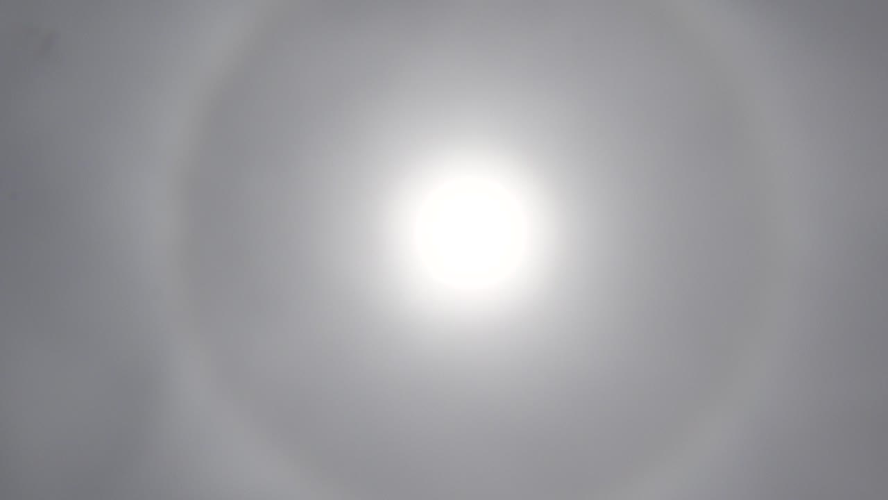 Bright white sun centered in a hazy gray-blue Los Cabos sky at the start of the clip, with no visible people.