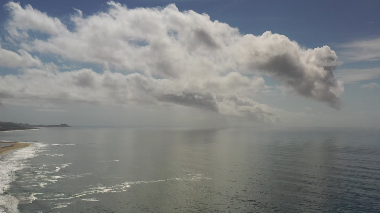 Wide ocean coastline under large gray clouds
