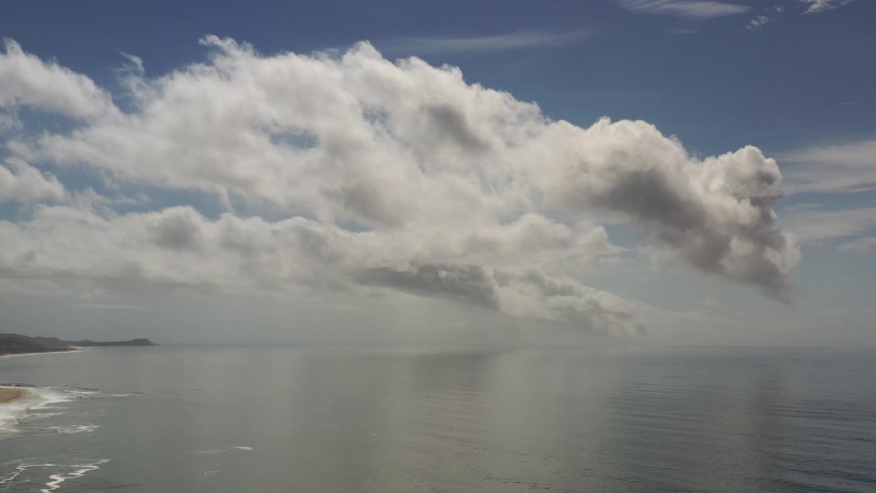 Wide ocean horizon beneath dense white cloud cover