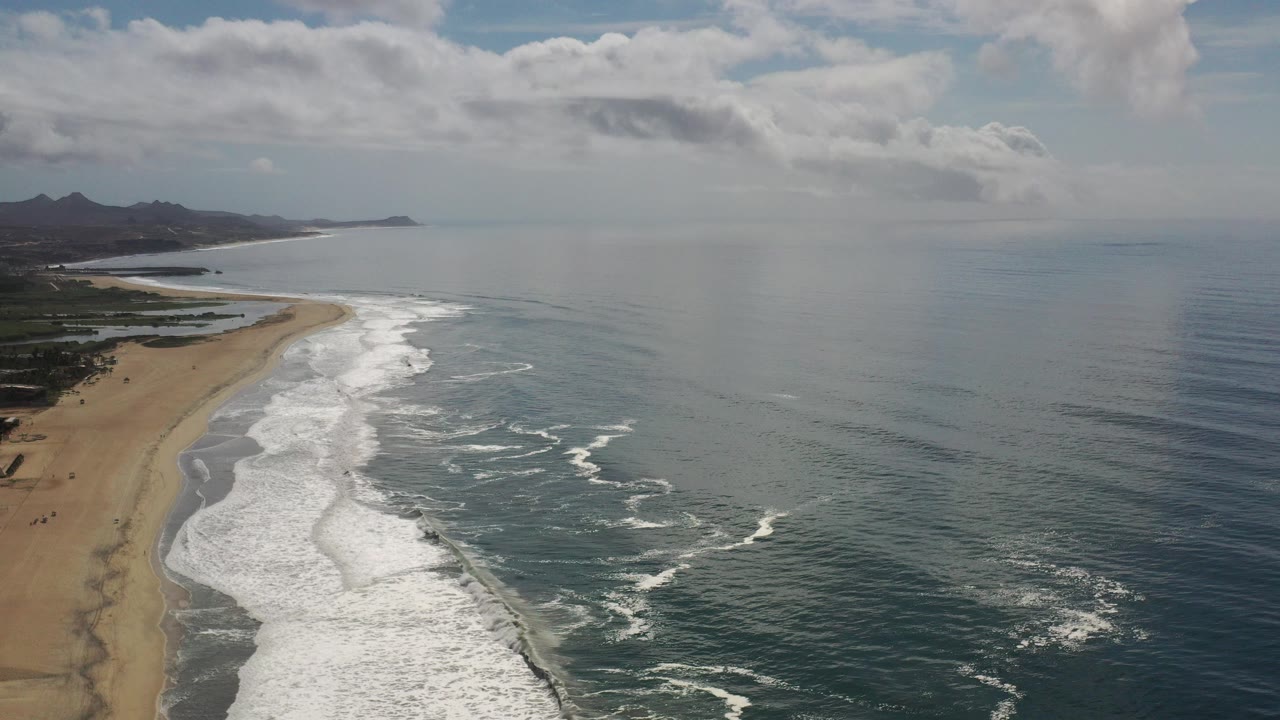 Aerial coastline with waves reaching a sandy beach