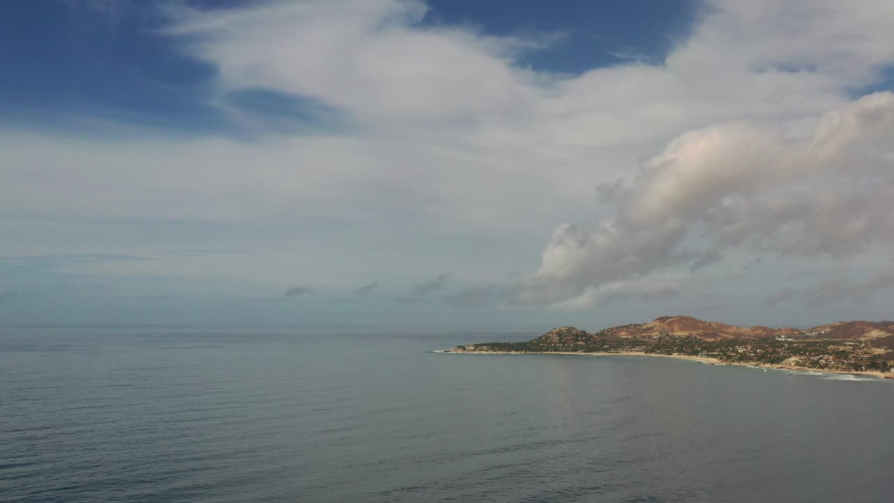 Coastal land on the right with open sea and sky.