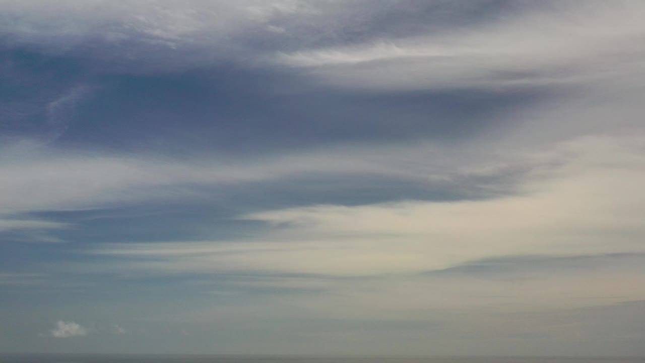 Opening frame of Los Cabos, Mexico with a large blue-gray cloud bank above the ocean horizon and no visible people.