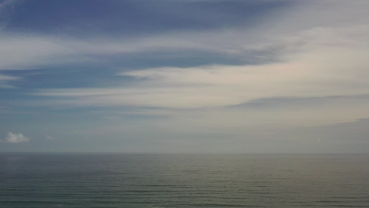 Opening view of the Los Cabos ocean horizon under broad blue-gray cloud layers, with no visible people.